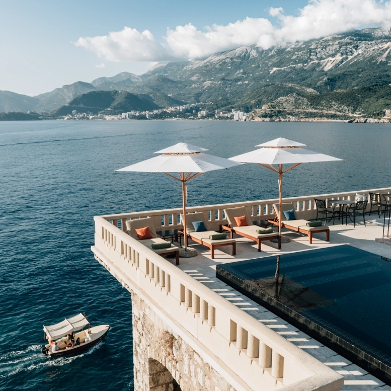 Terrasse avec piscine à débordement surplombant la mer Adriatique et les montagnes du Monténégro.