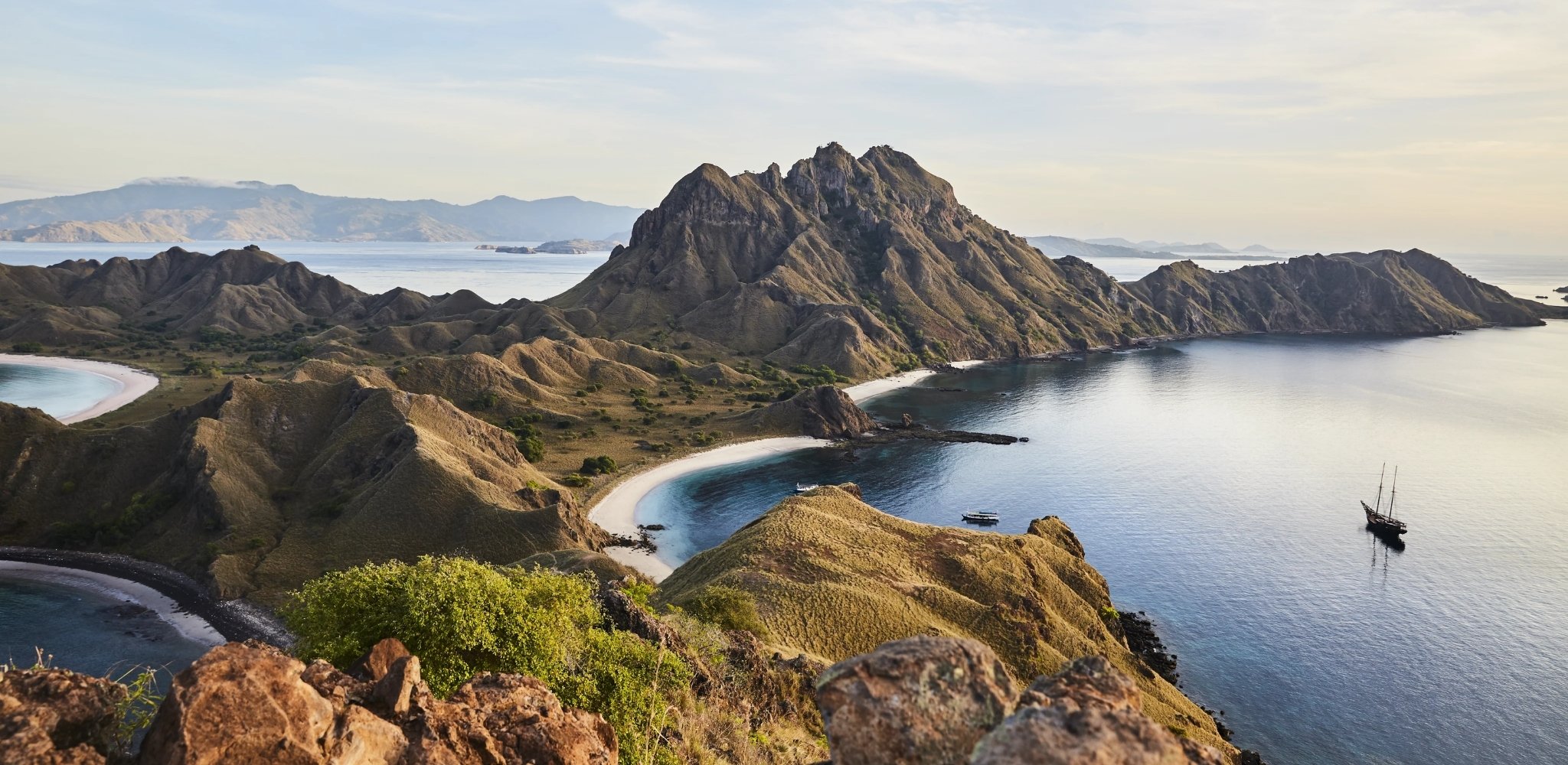Vue panoramique des îles de Komodo avec leurs plages sauvages, collines escarpées et eaux cristallines en Indonésie.