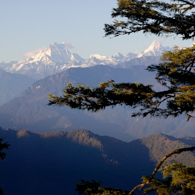 Panorama des sommets enneigés de l'Himalaya observés depuis les montagnes du Bhoutan. Voyage sur mesure au Bhoutan avec Horizons Nouveaux, agence de voyage basée en Suisse spécialiste du Bhoutan depuis plus de 30 ans
