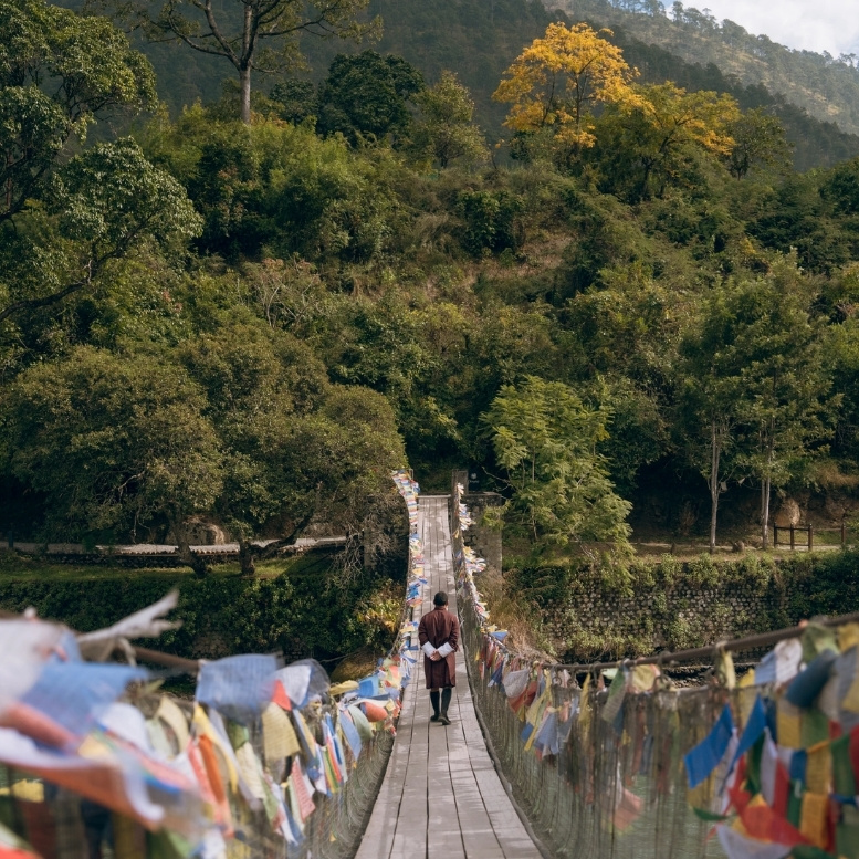 Pont suspendu orné de drapeaux de prières dans la vallée de Punakha au Bhoutan. Découvrez le Bhoutan lors d'un voyage sur mesure au Bhoutan avec Horizons Nouveaux, spécialiste du Bhoutan depuis plus de 30 ans