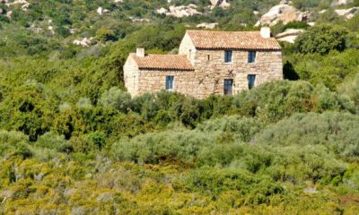 Maison traditionnelle en pierre nichée au cœur du maquis méditerranéen en Sardaigne.