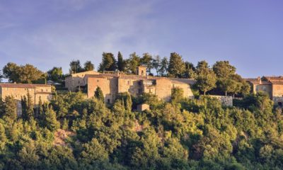 Village médiéval en pierre dominant les collines verdoyantes de Toscane.