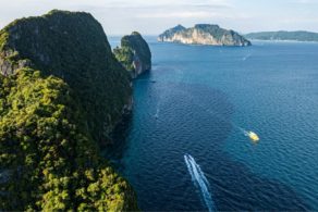 Vue aérienne de Koh Phi Phi Leh en Thaïlande, falaises karstiques couvertes de végétation tropicale, mer d’Andaman turquoise et excursion en bateau dans l’archipel de Krabi.
