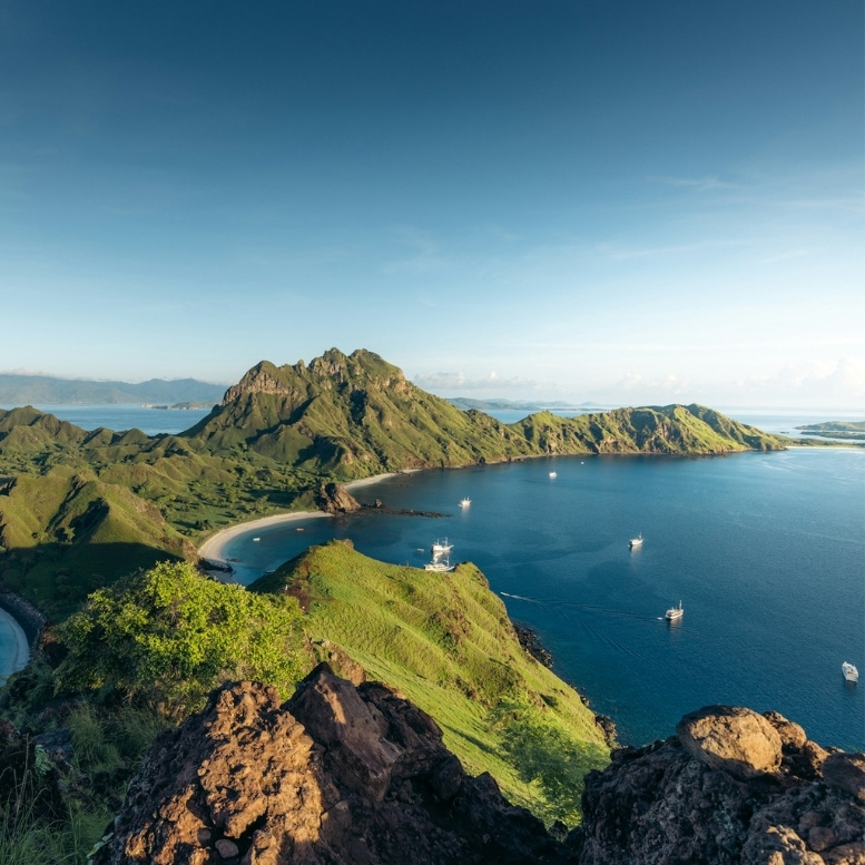 Vue panoramique du parc national de Komodo avec ses collines verdoyantes, baies sauvages et eaux turquoise en Indonésie.