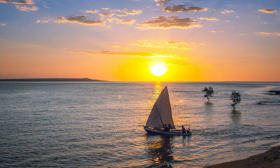 Pirogue à voile au large de Mahajanga à Madagascar au coucher du soleil, découverte des traditions maritimes et des paysages côtiers lors d’un voyage sur mesure à Madagascar.