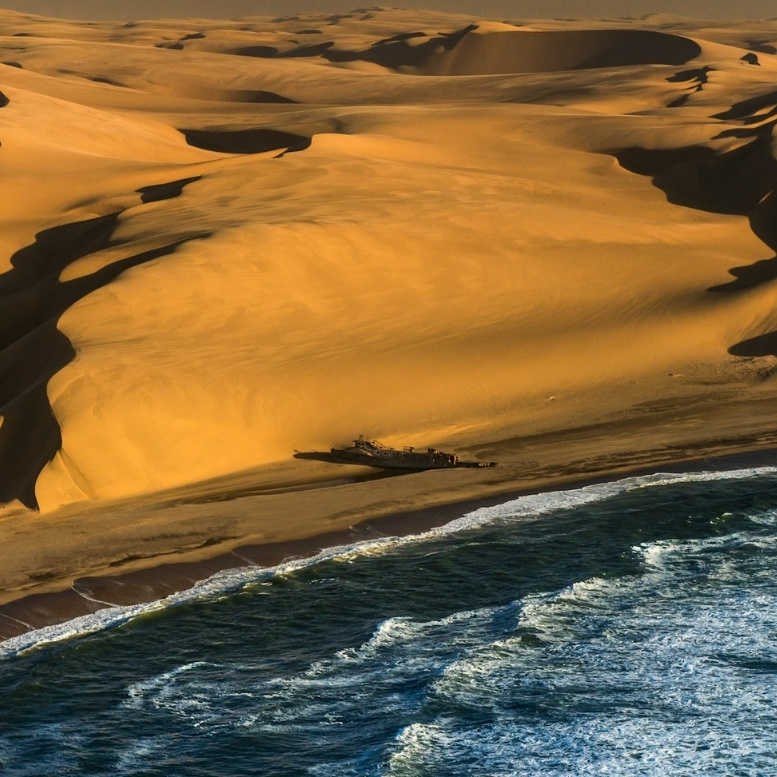 Épave échouée sur la Skeleton Coast en Namibie, côte mythique où les dunes du désert du Nam plongent dans l’Atlantique au cœur d’une nature extrême et préservée.