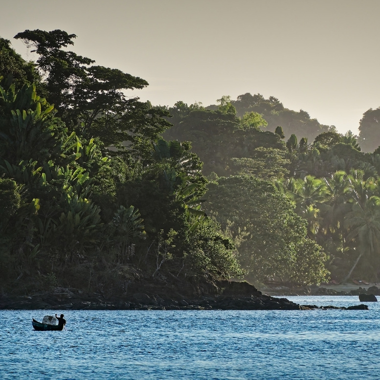 Pêcheur en pirogue devant la forêt tropicale de Madagascar près de Voaara, immersion dans la nature préservée et les paysages sauvages de l’océan Indien lors d’un voyage sur mesure à Madagascar.