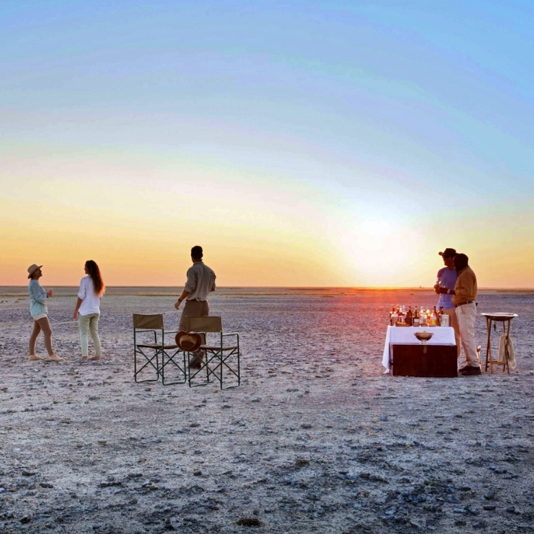 Coucher de soleil sur les pans salés de Makgadikgadi au Botswana avec apéritif privé en pleine nature.