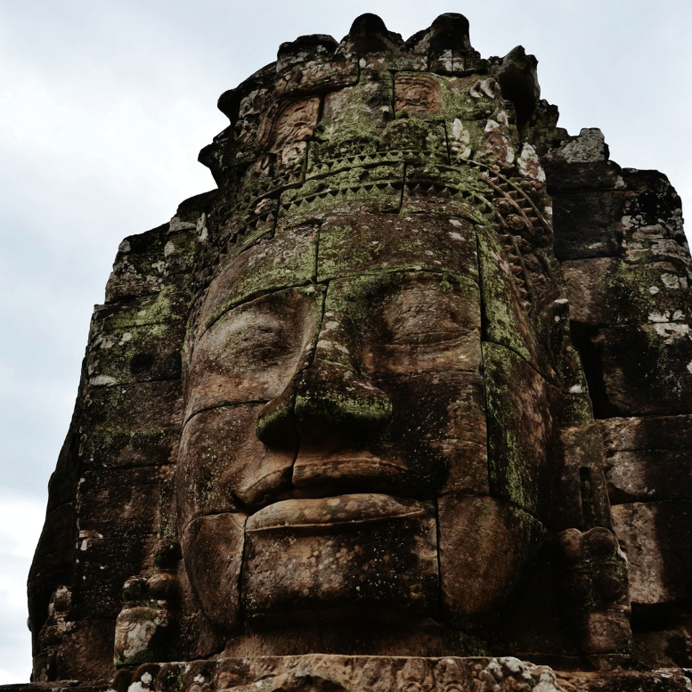 Visage monumental sculpté dans la pierre du temple du Bayon, au cœur de l’ancienne cité khmère.