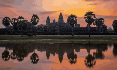 Angkor Wat : Les cinq tours du sanctuaire se reflètent dans les eaux paisibles du bassin, sous un ciel flamboyant. Voyage sur mesure au Cambodge avec Horizons Nouveaux, spécialiste de l'Asie depuis plus de 30 ans