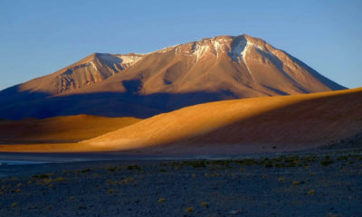 Volcan majestueux baigné par les dernières lumières du jour dans le désert du Sud Lípez en Bolivie.