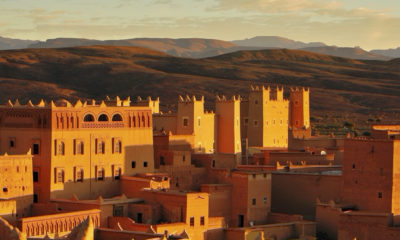 Village traditionnel en pisé baigné par la lumière dorée au cœur des paysages désertiques du sud du Maroc.