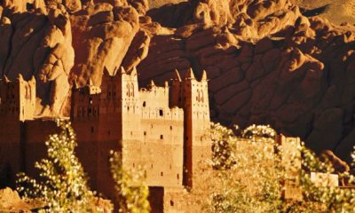 Ancienne kasbah en terre ocre dominée par les impressionnantes falaises rocheuses du sud marocain.