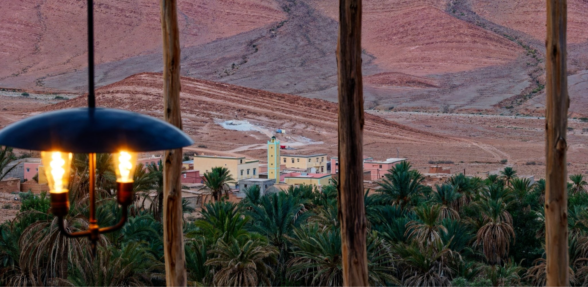 Vue sur une oasis et un village traditionnel depuis une terrasse dans la vallée du Drâa.