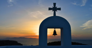 Chapelle blanche avec cloche en silhouette au coucher du soleil à Antiparos dans les Cyclades