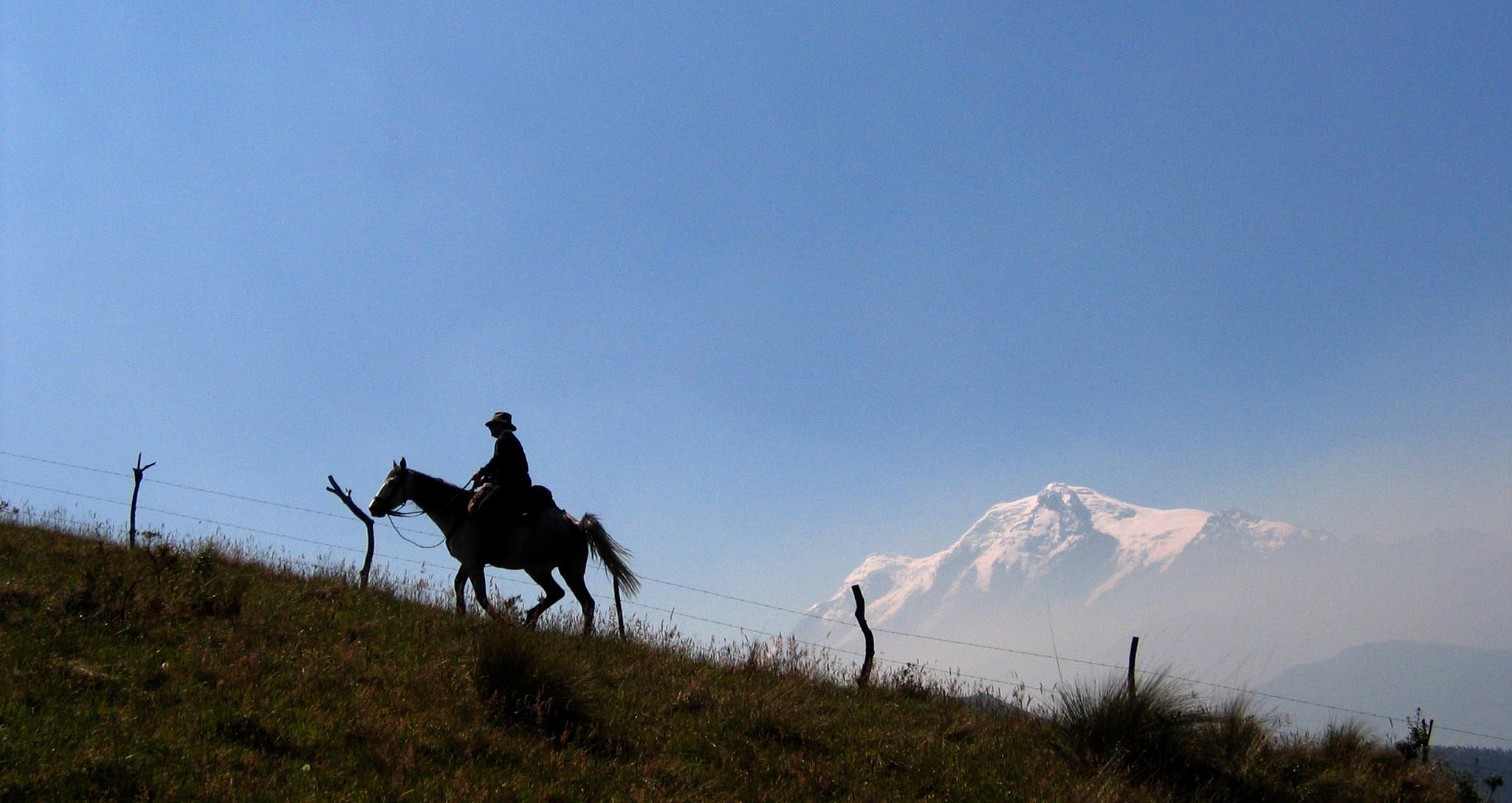 Équateur, cavalier face aux volcans des Andes près de l’Hacienda Zuleta.