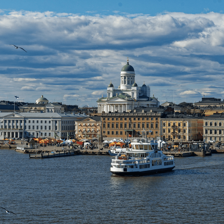 Vue sur le port d'Helsinki, ses bateaux et ses façades historiques, avec la cathédrale blanche dominant la capitale finlandaise.