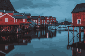 Cabanes de pêcheurs rouges sur pilotis dans un port des îles Lofoten, en Norvège, à la tombée du jour. Voyage sur mesure en Norvège et dans les Lofoten avec Horizons Nouveaux