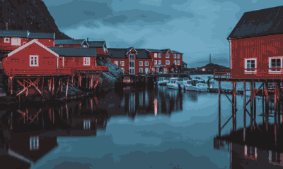 Cabanes de pêcheurs rouges sur pilotis dans un port des îles Lofoten, en Norvège, à la tombée du jour. Voyage sur mesure en Norvège et dans les Lofoten avec Horizons Nouveaux