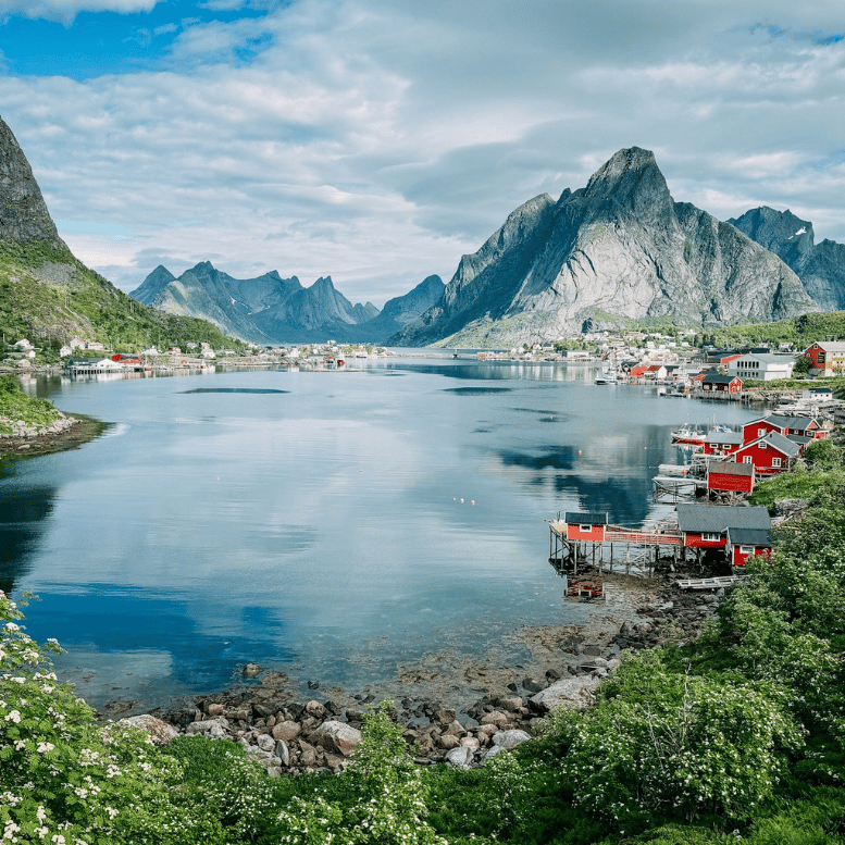 Village de pêcheurs de Reine, dans les îles Lofoten, avec ses maisons rouges au bord du fjord et ses montagnes spectaculaires.