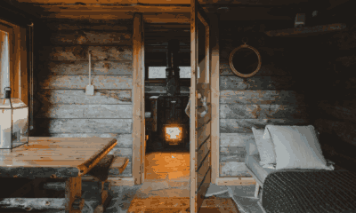 Voyage sur mesure en Finlande avec Horizons Nouveaux, spécialiste des voyages sur mesure. Intérieur chaleureux d’un chalet traditionnel en bois en Finlande, avec mobilier rustique, espace détente et poêle à bois allumé.