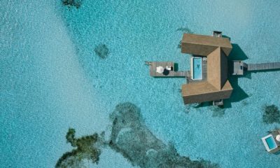 Vue aérienne du COMO Cocoa Island, île privée des Maldives entourée d’eaux cristallines, destination exclusive pour voyage haut de gamme.