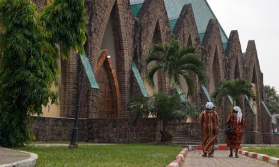Deux femmes se rendent à la basilique Sainte-Anne-du-Congo à Brazzaville, un monument emblématique connu pour son toit en tuiles vertes et ses arcs en pierre. a construction de cet édifice, conçu par l'architecte Roger Erell, a débuté en 1943 et s'est achevée en 2010.