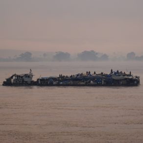 Un radeau sur le fleuve Congo. Ces convois de bois flottants servent au transport de marchandises et de personnes là où les routes sont rares ou impraticables. Les passagers voyagent souvent dans des conditions extrêmes sur ces embarcations pendant des périples qui peuvent durer un mois