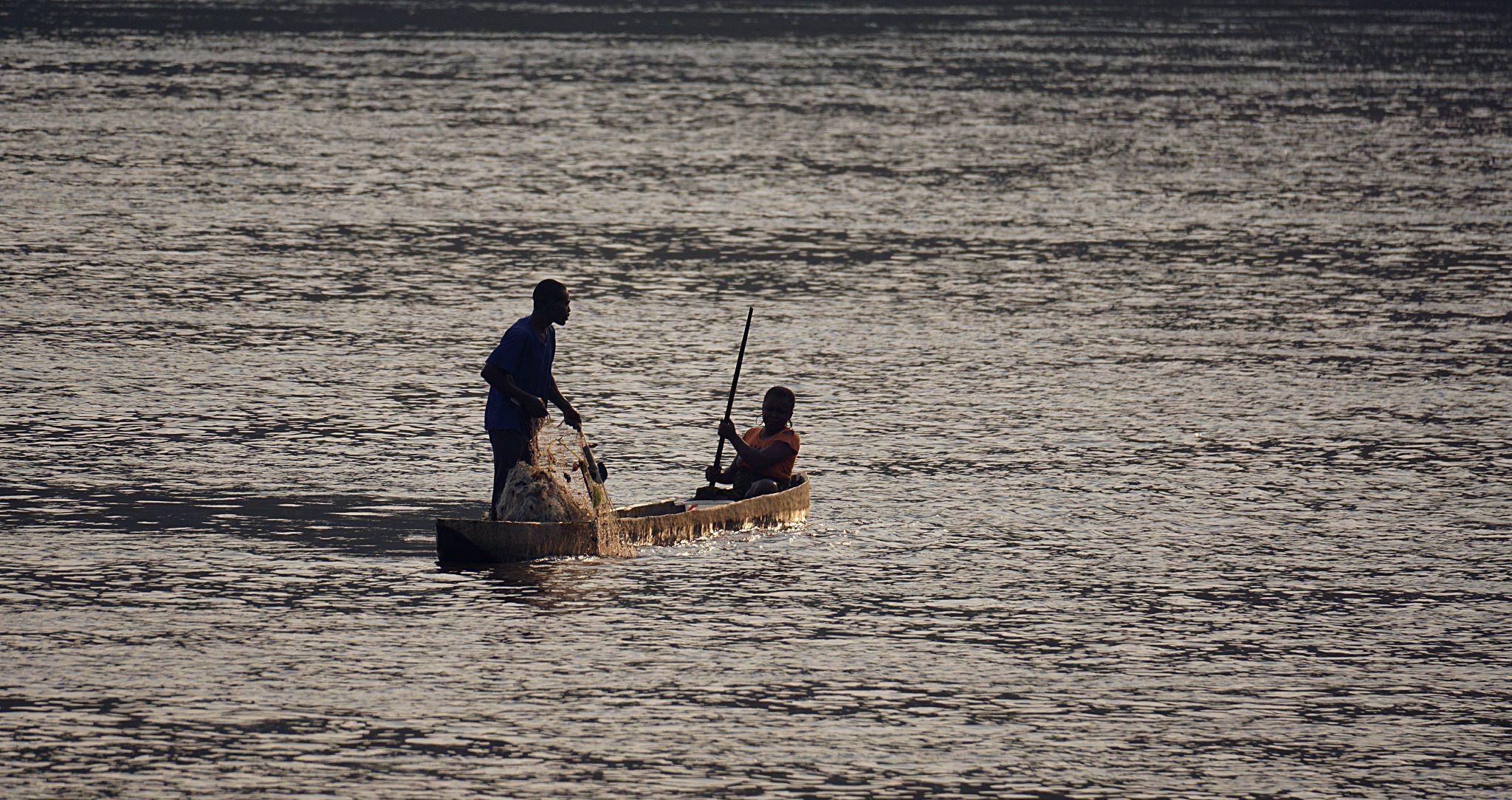 Deux villageois sur leur pirogue pêchent sur le Fleuve Congo.