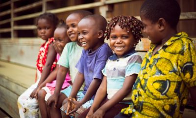 Des enfants du village de Mboko, à Odzala-Kokoua, rigolent assis sur un banc devant le photographe.